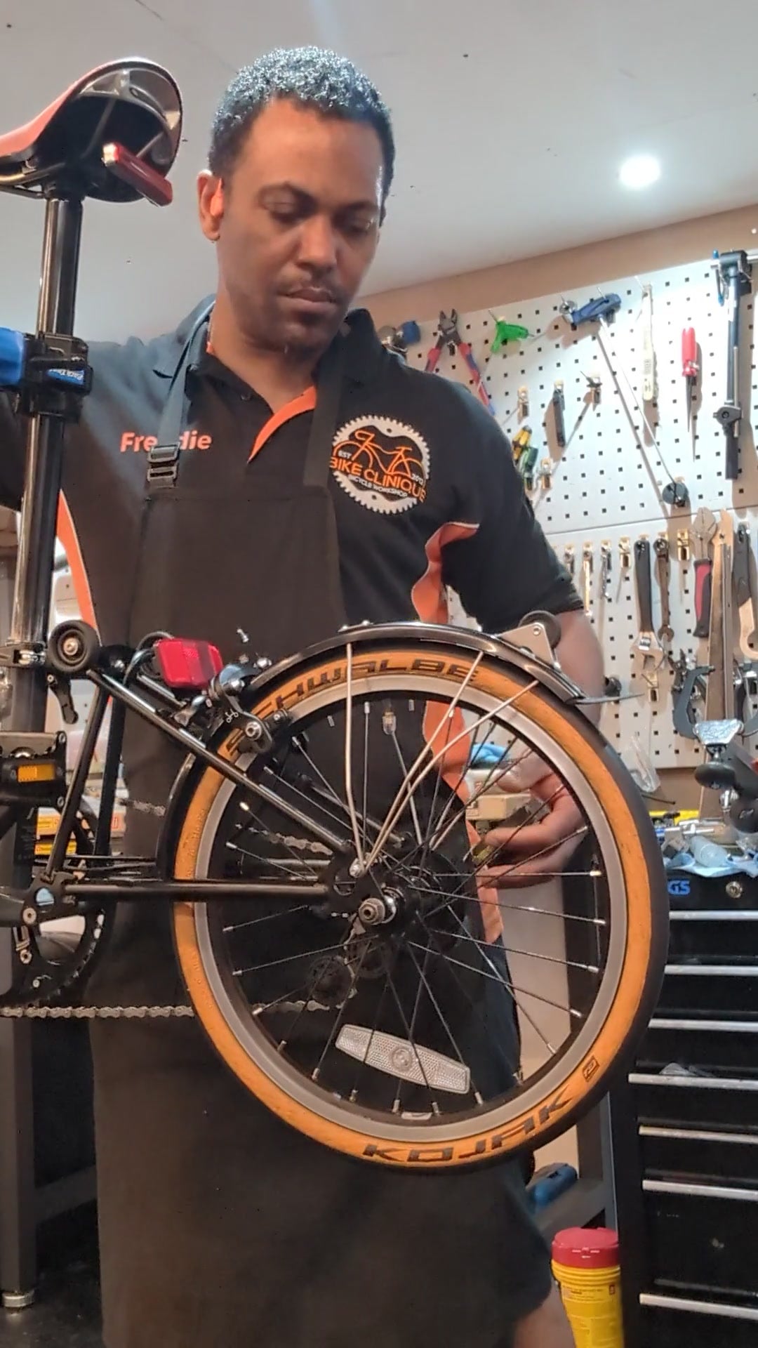 Freddie inspecting a Brompton rear wheel at the Bike Clinique workshop