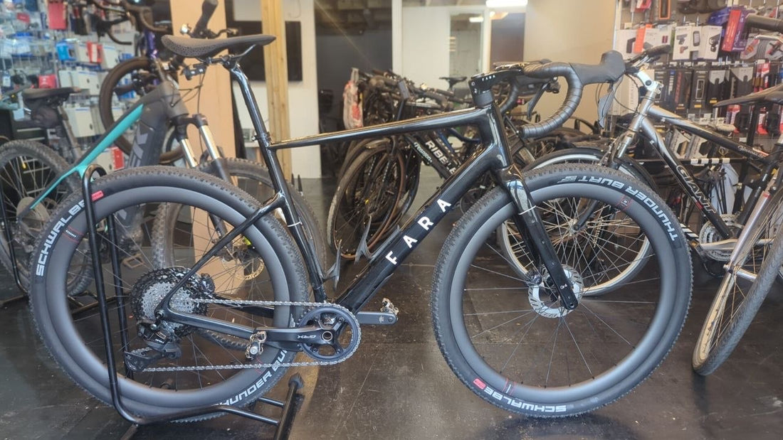 Black Fara drop-bar gravel bike with wide knobbly Schwalbe tyres, disc brakes and a wide-range cassette at the Bike Clinique workshop
